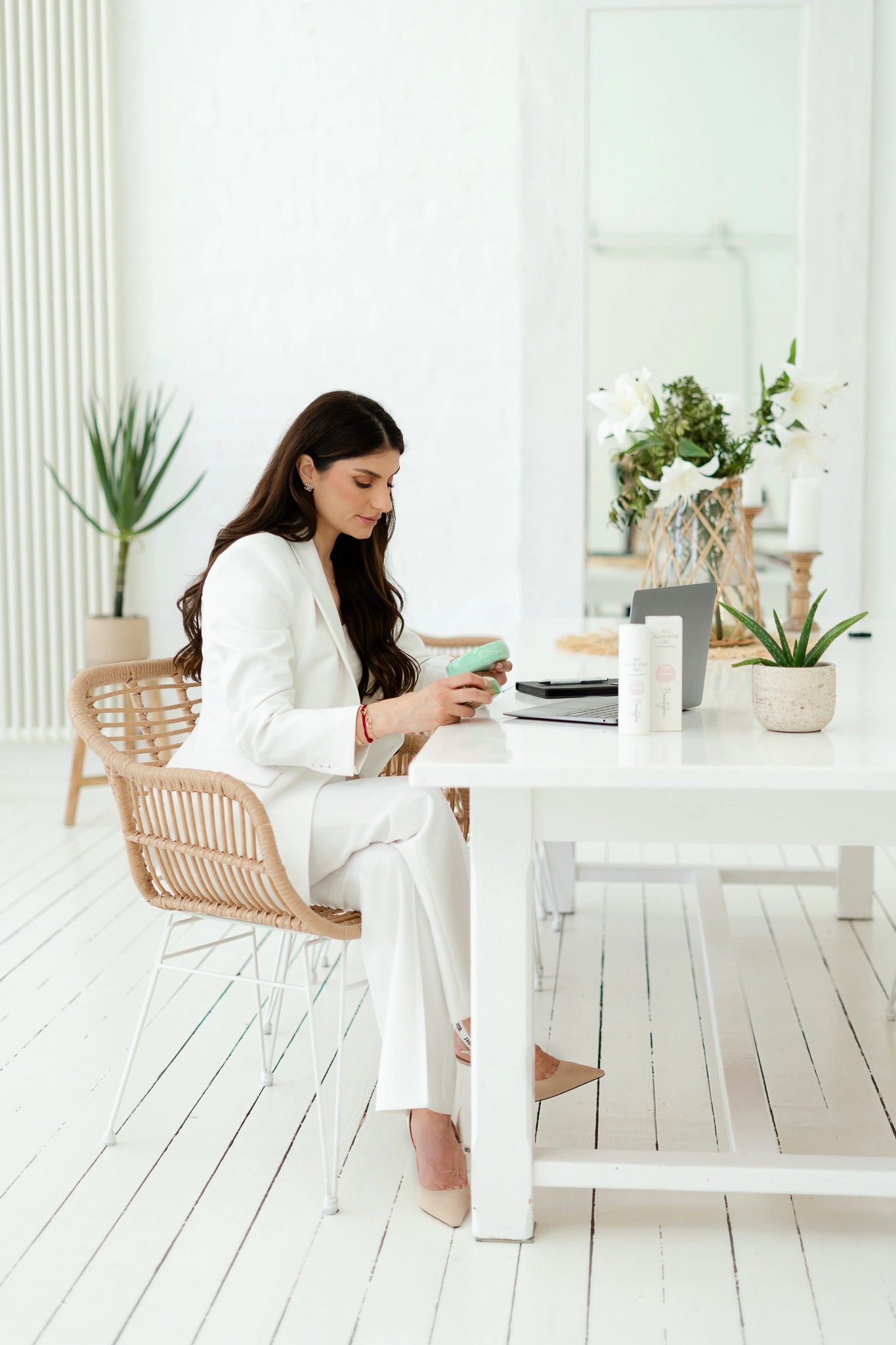 Frau am Schreibtisch mit Laptop und Beauty Produkten